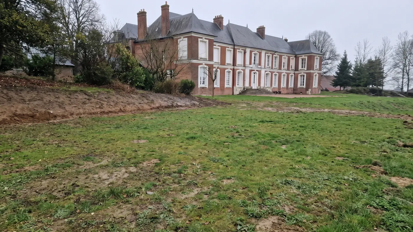 Avant les travaux — piscine et sa ceinture béton dans le parc d'une demeure en briques